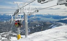 Skiers riding a chairlift at Schweitzer Mountain Resort above Lake Pend Oreille.