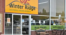 The storefront of Winter Ridge Natural Foods Market in Sandpoint, its yellow sign above windows marked Bulk Foods and Supplements.