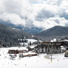 Schweitzer Mountain Resort village in winter, with skiers on the slopes below the village lodges and lifts